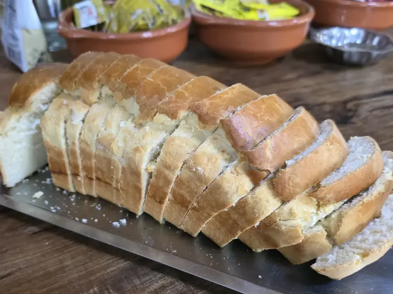 A loaf of homemade bread with a cut face showing the crumb.