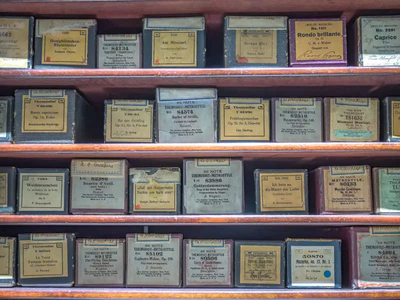 Boxes of piano rolls stacked on a shelf.