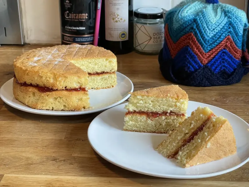 A Victoria sponge cake, risen evenly and filled with jam and cream.