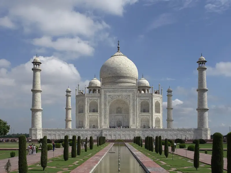 The Taj Mahal in Agra, its white marble dome and four minarets reflected in the watercourse.
